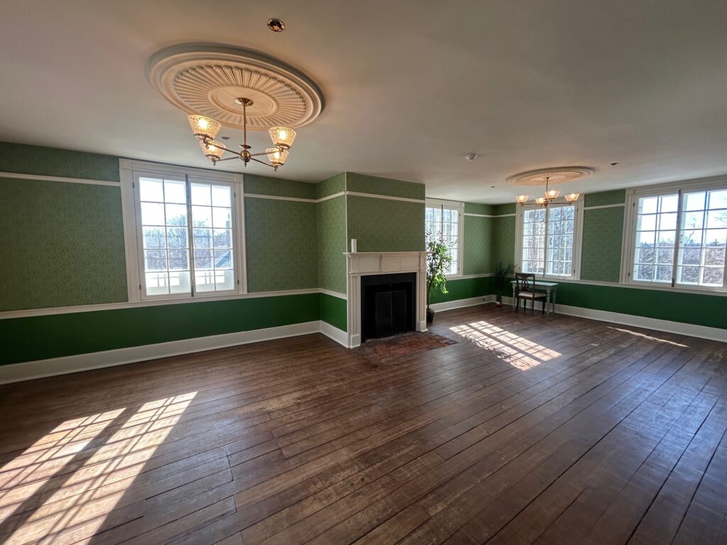 Wide angle photo of Billings Estate Museum. Including green ornate wallpaper, brown refinished flooring, period correct lighting fixtures with ornate WoodSource made medallions.